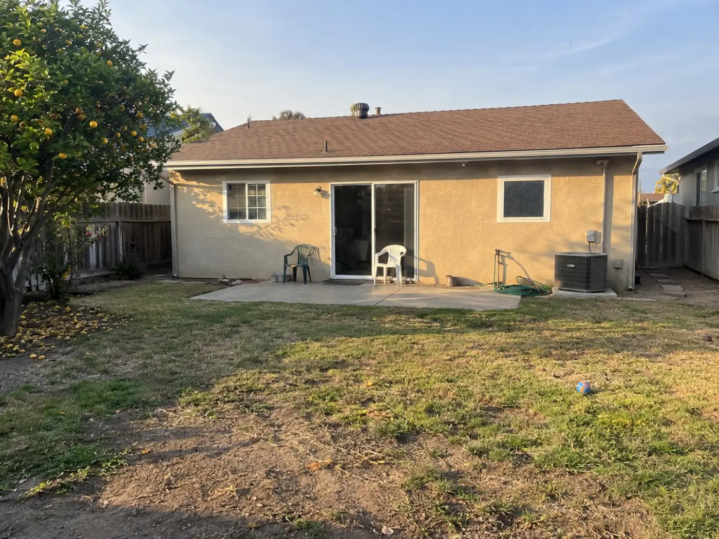 AI-generated starting condition: worn lawn and an old concrete slab at the house